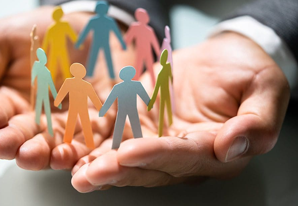 Hands holding paper cutouts of diverse people